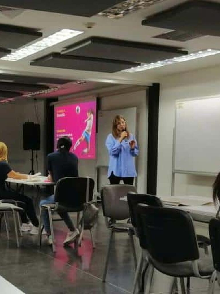 María Isabel Holguín, con micrófono, conduce una sesión de trabajo con un equipo