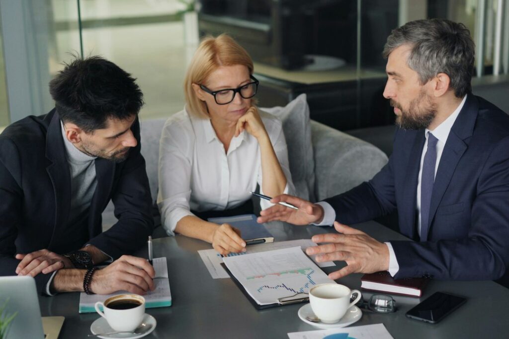 Tres directivos de distintas áreas discuten un reto en una reunión tensa
