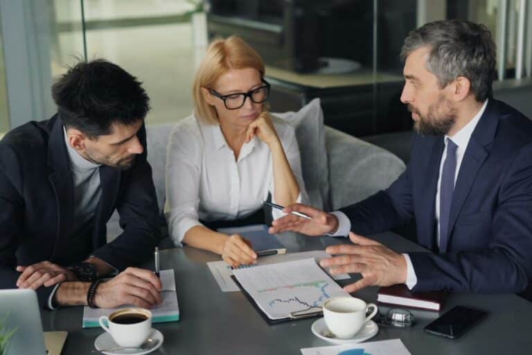 Tres directivos de distintas áreas discuten un reto en una reunión tensa